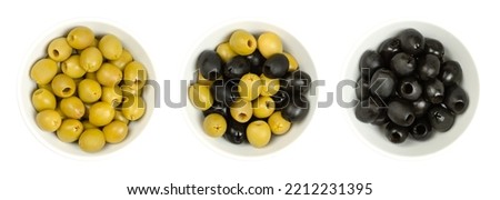 Pitted green and black olives, Hojiblanca, in white bowls, from above. European olives, Olea europaea, a cultivar from Lucena, Spain, mainly grown in Andalucia. Table olives with a lower oil content.