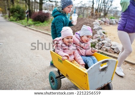 Kids at wooden trolley at the zoo.