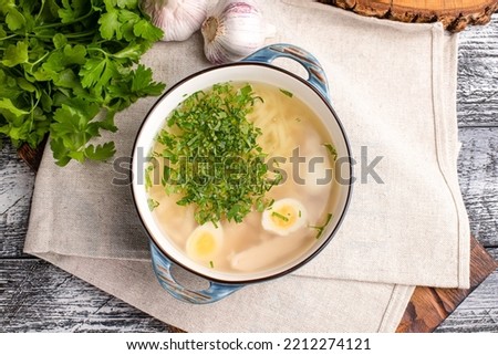 Chicken soup, soup with chicken and herbs on a wooden white background