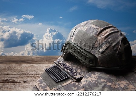 USA military uniform with insignias on old wooden table on blue sky background.
