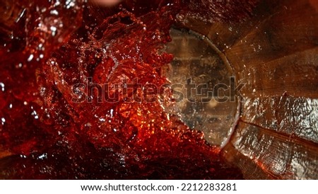 Freeze motion of splashing red wine in wooden barrel. Concept of pouring wine inside a keg. Alcoholic beverage background. Royalty-Free Stock Photo #2212283281