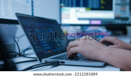 specialist programmer man hand type configuration code on at laptop for check software function for fix bug and defect of security system in dark datacenter room for engineering and technology concept Royalty-Free Stock Photo #2212285889