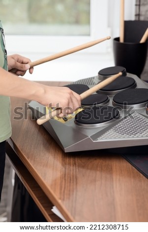 Hands of a young musician playing electronic drums with sticks, close-up, selective focus Royalty-Free Stock Photo #2212308715