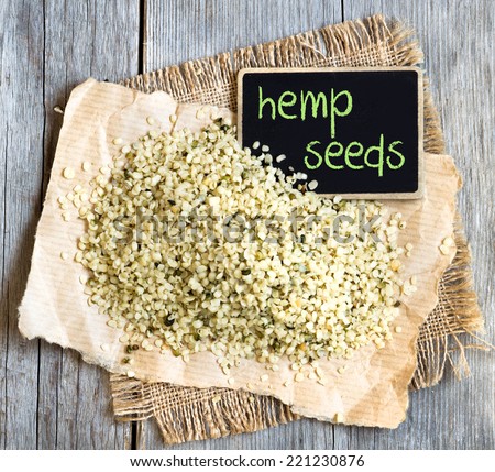 Hemp seeds on wooden table with small chalkboard Royalty-Free Stock Photo #221230876
