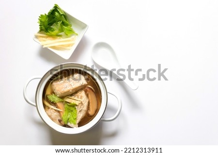 Pot of soup with sea bass fish and herb, healthy meal. Overview shot isolated on white background with copyspace.