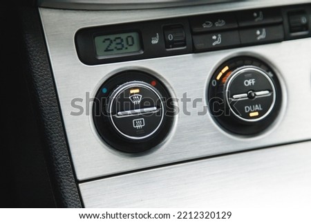 Illuminated button for activated dual-zone climate control and windshield defrost in the car. Royalty-Free Stock Photo #2212320129