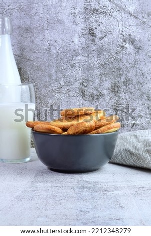 Sweet palm leaf pastries, accompanied by a good glass of milk. Vertical shot and copy space.