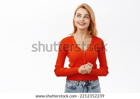 Portrait of young redhead woman holding hands together in professional pose, smiling friendly at customer or client, standing over white background