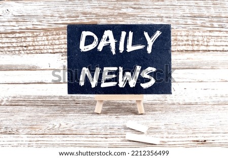 DAILY NEWS text on Miniature chalkboard on wooden background