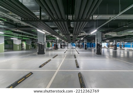 An empty underground parking lot of a shopping center or the interior of a garage with concrete columns.