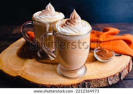 Pumpkin Spice Hot Chocolate Topped with Whipped Cream: Mugs of hot chocolate topped with chantilly cream and pumpkin spice