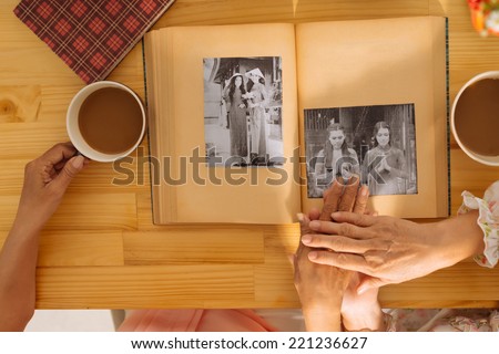 Senior women watching photo album, view from the top