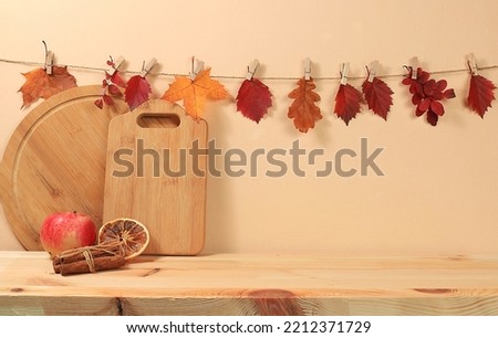 Empty kitchen wooden table for product display and maple leaves, minimal autumn concept, creative autumn composition with screen banner.