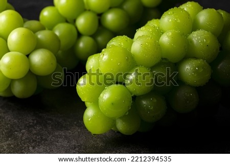 Shine Muscat with water droplets placed on black background. White grapes. Japanese grapes. Royalty-Free Stock Photo #2212394535