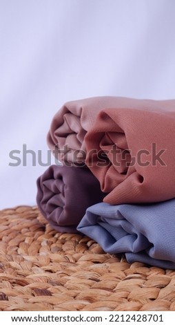 4 variants of the hijab rolled up with a rattan base using a white background.