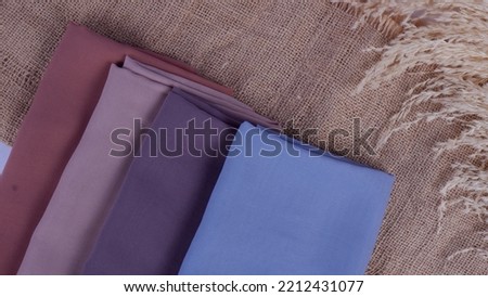 4 variants of the hijab are folded using a burlap background.
