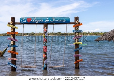 Several posters with words in Portuguese next to two hammocks in the Carcara lagoon. Words of good vibes for tourist photos.