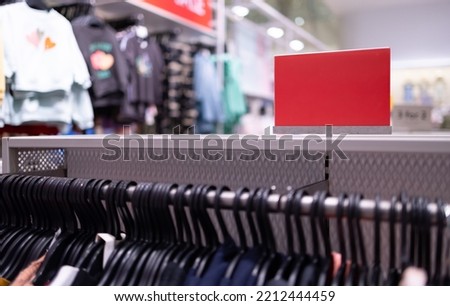 Close up clothes hangers on rack with anti theft alarm. Background for fashion retail shop shop and apparel store.