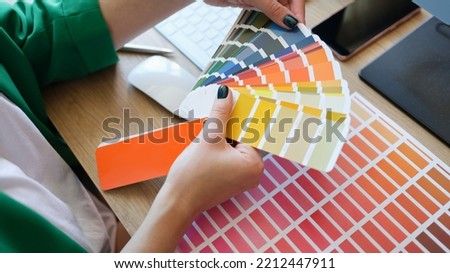 Top view of interior designer choosing fan of colourful samples. Woman searching colour for promotion project. Design and art concept