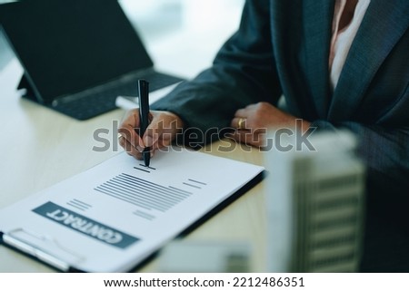 A businesswoman or a female business owner signs important documents to borrow money for investment in real estate or homes with the bank.