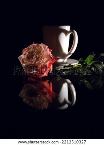 Valentine's day, close-up coffee cup and rose on a mirror table. Creative chiaroscuro in the shape of a heart. Holiday postcard. Royalty-Free Stock Photo #2212510327