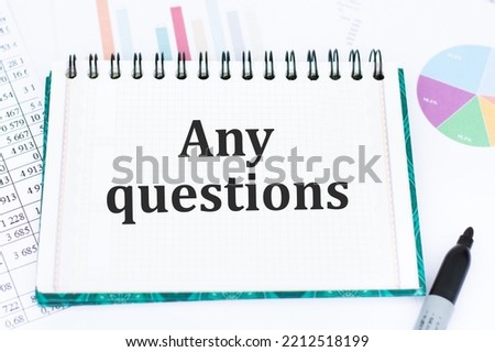 ANY QUESTIONS text written on a notebook on the table