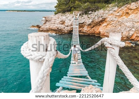 man walking by suspension bridge summer time copy space