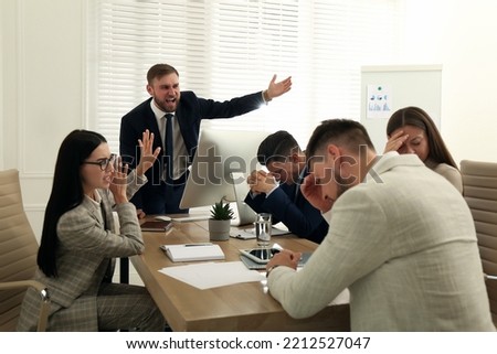 Boss screaming at employees on meeting in office. Toxic work environment Royalty-Free Stock Photo #2212527047