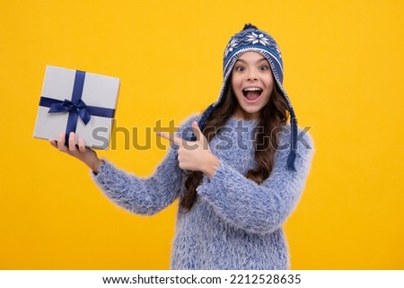 Child with gift present box on isolated background. Presents for birthday, Valentines day, New Year or Christmas. Excited teenager girl.