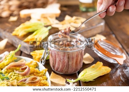 Anchovies in a jar, on a wooden rustic background. Traditional italian food of the south of italy and sardinia. Anchovy Fillets. small but herring. Copy space
