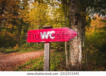 Toilet signpost in the middle of the autumn colored forest