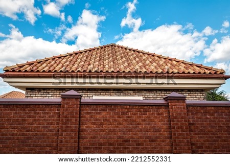 Ceramic roof tile triangle and brick fence under blue sky