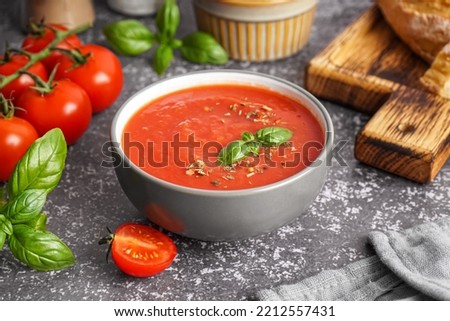 Bowl of delicious tomato soup on grunge background Royalty-Free Stock Photo #2212557431