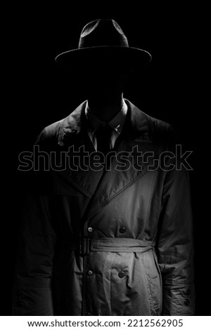 A dark silhouette of a man without a face in a coat and hat in the noir style. A dramatic portrait in the style of detective films of the 1950s and 60s. The silhouette of a spy.