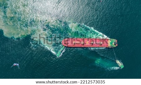 Tug Boat drag Barge ship carry Metal steel pipe construction unit , No International Sewage sludge Pollution Prevention Certificate, Sewage Sludge in the sea made by Activity of ship concept Royalty-Free Stock Photo #2212573035