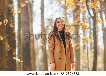 Having good mood. Woman in coat have walk in the autumn forest.