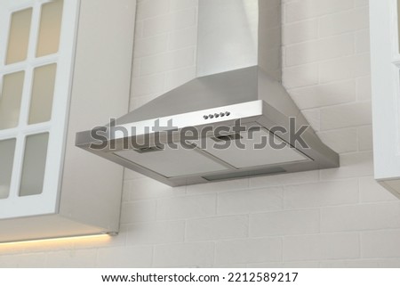Modern range hood on white brick wall in kitchen Royalty-Free Stock Photo #2212589217