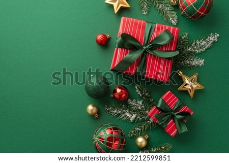 Christmas decorations concept. Top view photo of present boxes with ribbon bows red green and gold baubles star ornaments and pine branches in frost on isolated green background Royalty-Free Stock Photo #2212599851