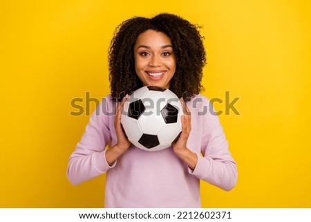 Photo of young girl good mood play football match sportive competition goal isolated over yellow color background.