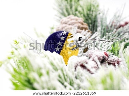 New Year's colorful background with a ball on which the flag of Bosnia and Herzegovina is depicted. The concept of the New Year holiday and Christmas.