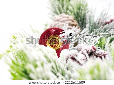 New Year's colorful background with a ball on which the flag of Kyrgyzstan is depicted. The concept of the New Year holiday and Christmas.