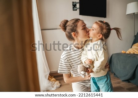 Affectionate mother giving a kiss to her daughter