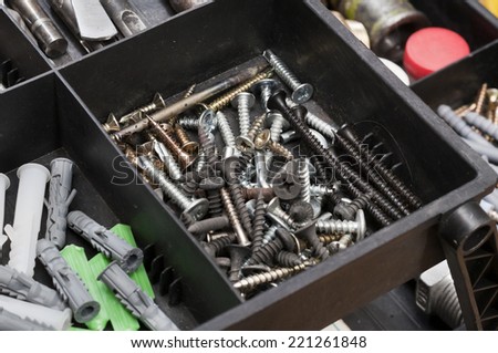Metal workshop. Plastic toolbox with screws, bolts and some tools.