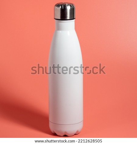 White Thermal bottle on a pink background. Thermos bottle close-up. Royalty-Free Stock Photo #2212628505