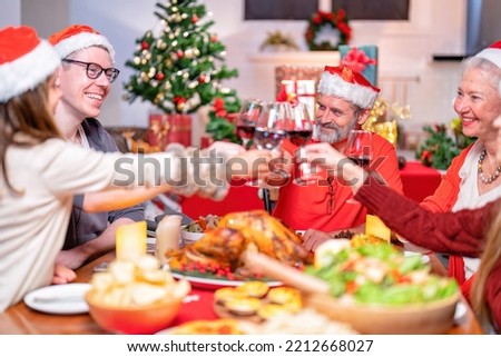 At home family decoration gift box in background on festive christmas tree and cheerful serving roasted turkey and cheers drink red wine talking to each other while dinner