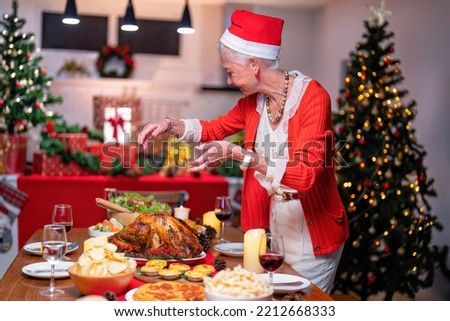 Grandma decoration gift box in background on festive christmas tree and cheerful serving roasted turkey dinner and red wine with set of food fruit and sweet desert on table