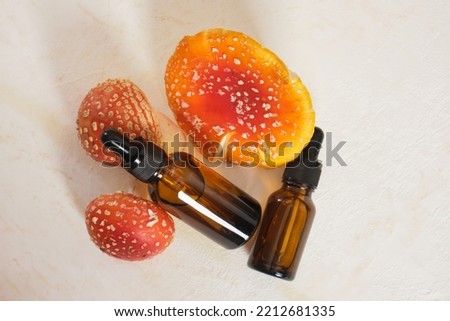 fly agaric red and amber glass dropper bottles, fly agaric extract for skin and joints treatment, fly agaric microdosing, biohacking to improve the state of the body and mind Royalty-Free Stock Photo #2212681335