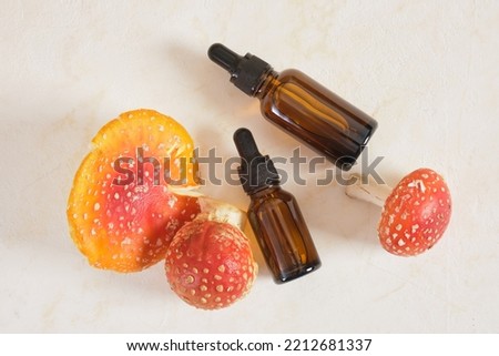 fly agaric red and amber glass dropper bottles, fly agaric extract for skin and joints treatment, fly agaric microdosing, biohacking to improve the state of the body and mind Royalty-Free Stock Photo #2212681337
