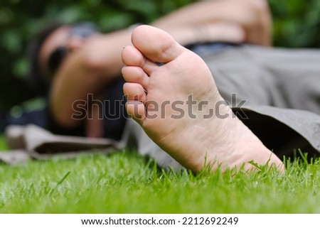 Foot of man lying on the grass