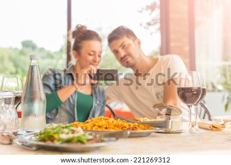Two friends at lunch - Couple of lovers taking a self portrait at italian restaurant